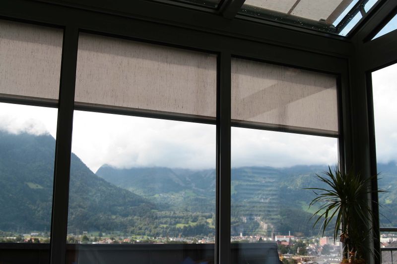 Wintertuin met half verlaagd verticaal scherm markilux 710, uitzicht op de bergen.