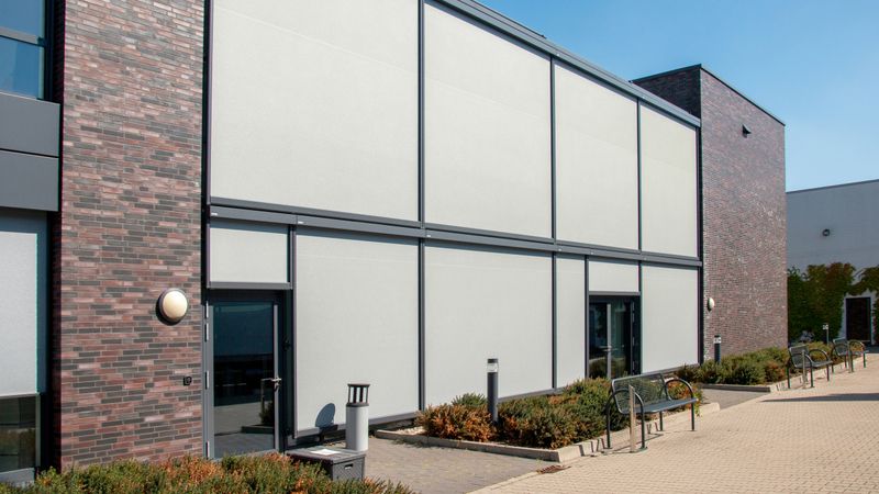 Kantoorgebouw uitgerust met markilux 625 verticale schermen als zonwering voor het interieur.