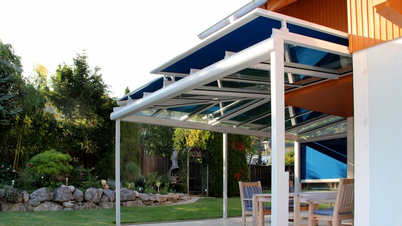 Imagen de referencia de un toldo markilux 870 con lona azul en el techo de terraza.