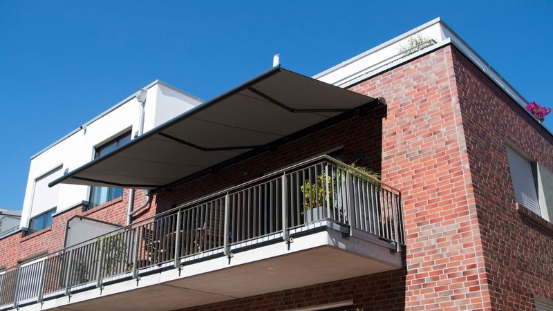 Reference image: markilux 5010 cassette awning covers a balcony of a modern brick house.