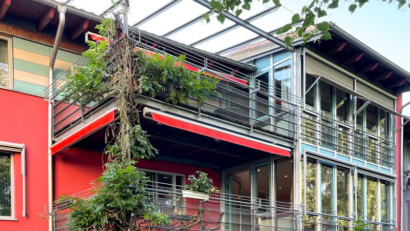 Diverse tende da sole markilux 1710 retratte su un edificio rosso per ombreggiare i balconi.