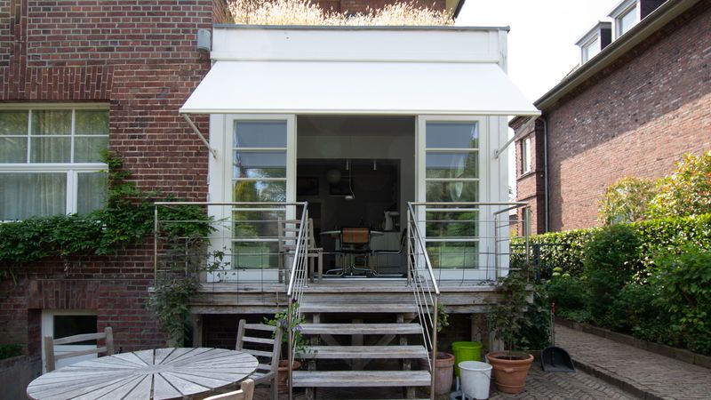 Witte uitval-cassetteschermen markilux 730 bevestigd voor een raam boven een terras.