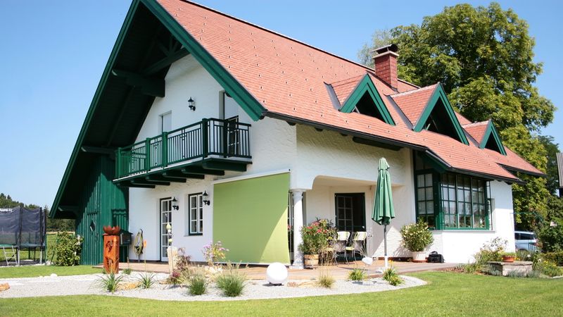 Toldo vertical markilux 710 com tecido verde como proteção solar e contra o vento para o pátio.
