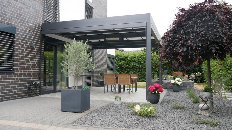 Reference til en fritstående terrasseoverdækning markilux markant med lys markisedug.