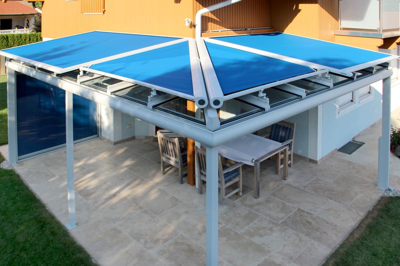 Techo de terraza equipado con toldos markilux, lona de tejido azul, extendida.