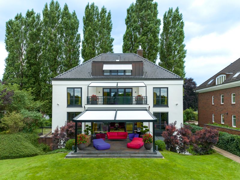Casa com proteção solar total através de toldo de janela, pérgola na varanda e no terraço, visualmente coordenados entre si e com a casa.