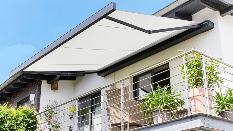 Cassette zonnescherm markilux 970 met lichtdoek op balkon van wit huis