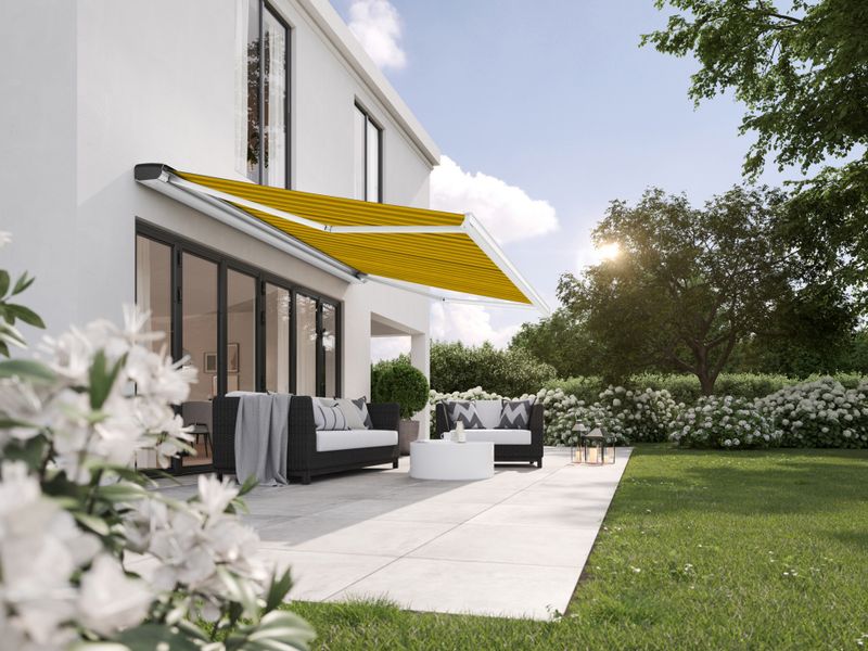markilux MX-2 com cassete de duas cores e tecido às riscas amarelas e pretas sobre um terraço.