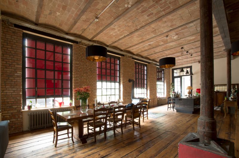 Interiørbillede af murstensbygning, loftslignende, med røde markilux lodrette vinduer