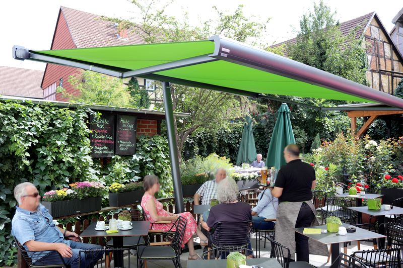 MX-3 cassette awning with green fabric cover as awning parasol in a beer garden.