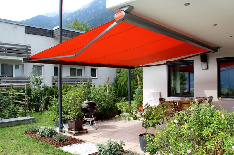 Tenda a cassonetto MX-3 con telo della tenda da sole rosso, montata a soffitto su una terrazza.
