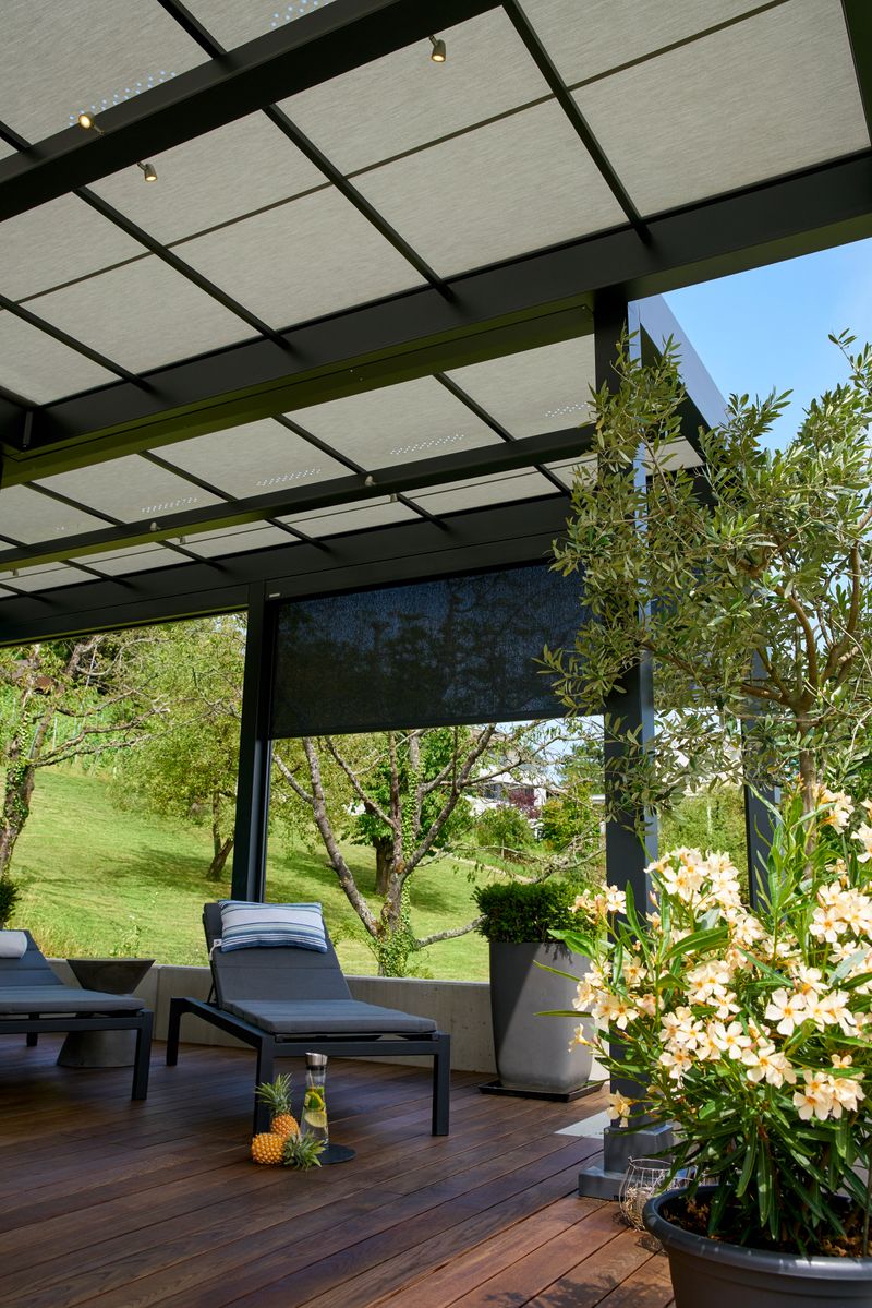Referentie vrijstaande terrasoverkapping markilux markant met licht schermdoek gecombineerd met verticaal scherm, onderaanzicht.