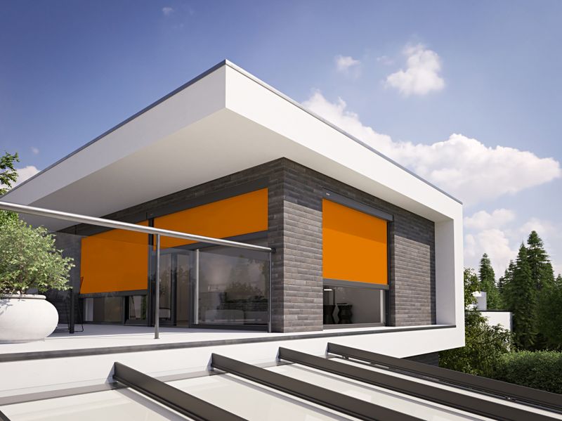Övre våningen på ett platt tak. Fasad i mörkt tegel med orange vertikala blinderingar.